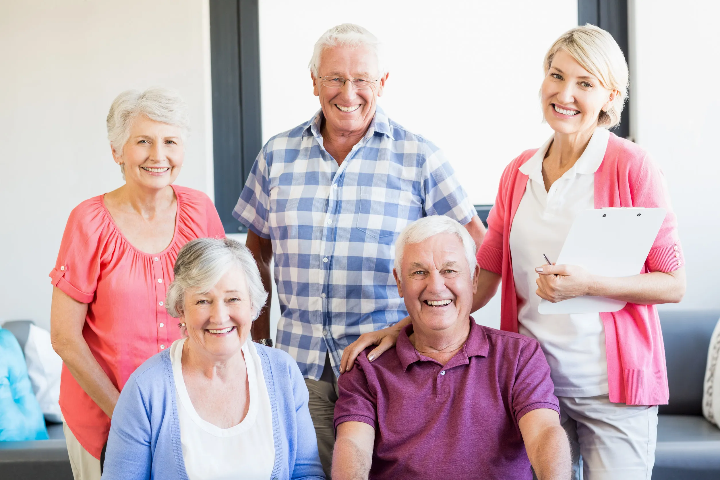 Nurse and seniors standing together in a retirement home